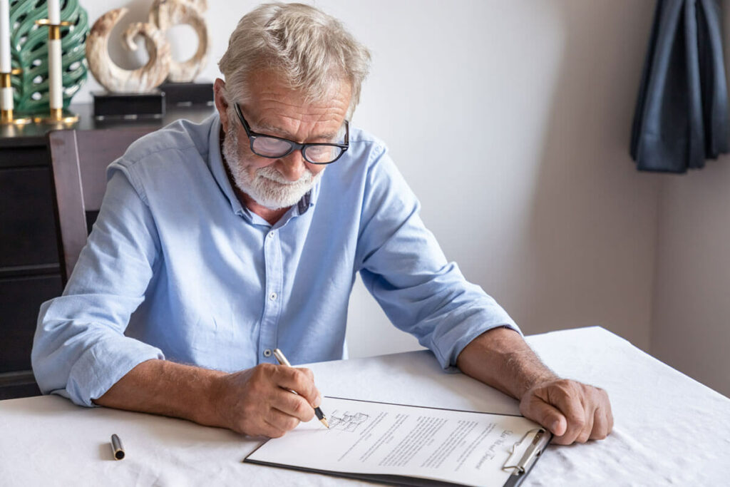 elderly examining and signing last will and testament